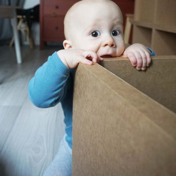 Papiermöbel Baby klettert auf Papphocker